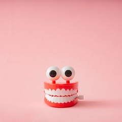Plastic toy teeth against pastel background. Abstract minimal composition.
