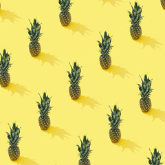 Tropical pineapple pattern on pastel yellow backround. Minimal summer fruit concept.