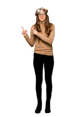 Obraz na płótnie Canvas Full-length shot of Young woman with beret frightened and pointing to the side on isolated white background