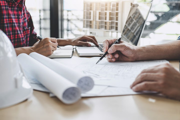 Hands of architect or engineer working on blueprint meeting for project working with partner on...