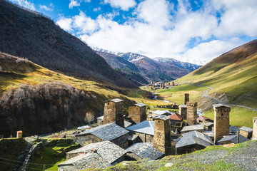 Picturesque landscape of aged Georgian rural community Ushguli with Typical Svaneti defensive tower houses in valley of beautiful mountains with snowy peaks, UNESCO World Heritage Site