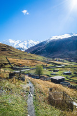Picturesque landscape of aged Georgian rural community Ushguli with Typical Svaneti defensive tower houses in valley of beautiful mountains with snowy peaks, UNESCO World Heritage Site