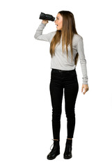 Full-length shot of young girl and looking in the distance with binoculars on isolated white background