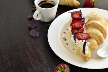Croissant with cream cheese, strawberries and basil for breakfast,  copy space