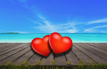 Fototapeta premium Red heart on wooden floor, bridge with sea as background.
