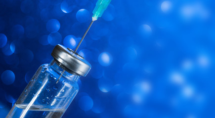 Injection vial with syringe needle on blue background