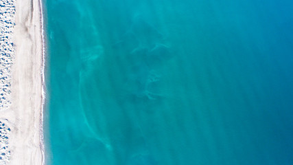 Sand, rock, and sea patterns on cristal clear waters.