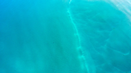 Sand, rock, and sea patterns on cristal clear waters.