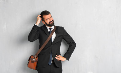 Businessman with beard having doubts while scratching head