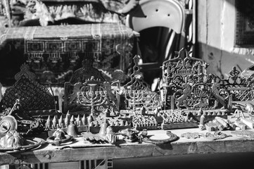 Different Hannukah menora and other candlesticks at the flea market in Old Jaffa, Israel. Judaica background. Selective focus. Black white historic photo