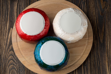 Colorful cheese packs on wooded table.