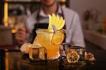 Fresh alcohol Penicillin cocktail with orange slice and ice cubes. Barmen making alcohol cocktail	