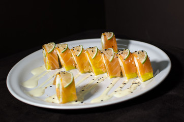 Sushi rolls in white plate and dark background