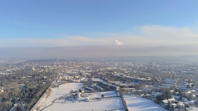 Flying over the snow covered german city of Aachen in the Eifel region