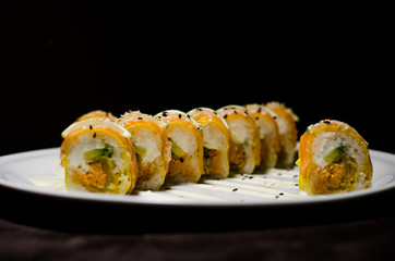 Sushi rolls in white plate and dark background