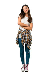 A full-length shot of a Teenager girl with shirt tied to the waist keeping the arms crossed in...