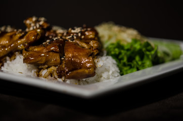 Teriyaki chicken in white plate and dark back ground.