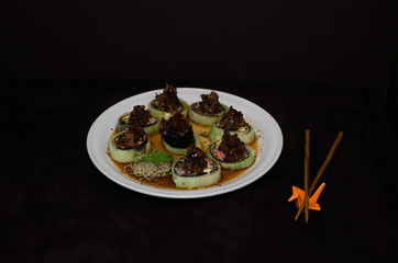 Sushi rolls in white plate and dark background