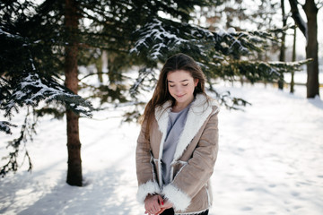 Young Beautiful girl  Smiling and posing Outdoors in Snowy Winter