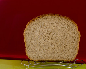 Section of the white loaf prepared in an electrooven on a red-green background.