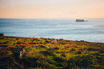 Filfla Island in Mediterranean Sea, view from Malta. Sunset warm light