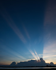 Sunset with light streaks and half of sky lit by setting sun