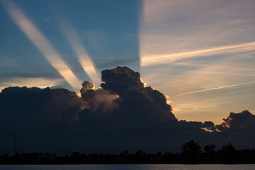 Sunset with light streaks and half of sky lit by setting sun