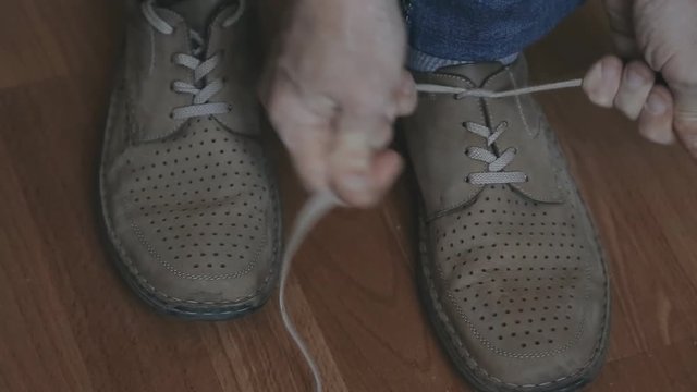 Man tying old shoes. Close up