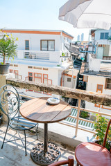 Beautiful terrace or balcony with small wooden table, chair and tree with evening city view, Garden cafe