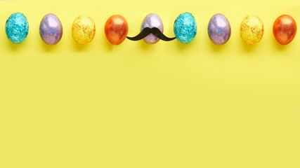 pattern with easter eggs on a yellow background. and one egg with a mustache. concept is like that all. free space for text