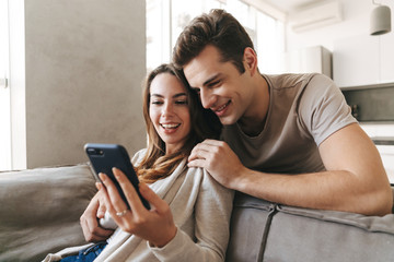 Smiling young couple relaxing on a couch at home