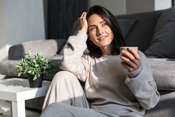 Obraz premium Beautiful young woman relaxing at a couch at home