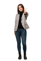 A full-length shot of a Young business woman smiling and showing victory sign over isolated white background