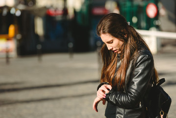 Young woman arrives late for an appointment, while waiting in the street.