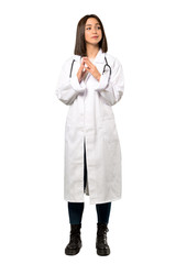A full-length shot of a Young doctor woman scheming something over isolated white background