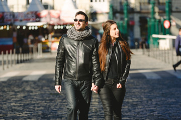 Obraz premium couple walking in the sun through a city.