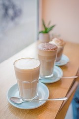 Three glasses of coffee drinks. Coffee latte and coffee mocha near the window