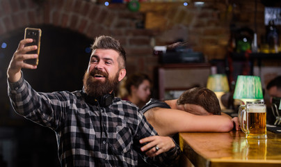 Man bearded hipster hold smartphone. Taking selfie concept. Online communication. Send selfie to friends social networks. Man in bar drinking beer. Take selfie photo to remember great evening in pub