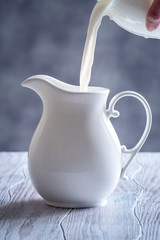 Fresh milk is pouring into the jug