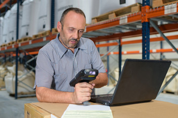 worker checking goods with barcode scanner