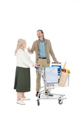 retired husband talking with wife holding shopping trolley isolated on white