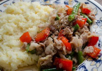 couscous, meat, bell pepper and green beans on a plate