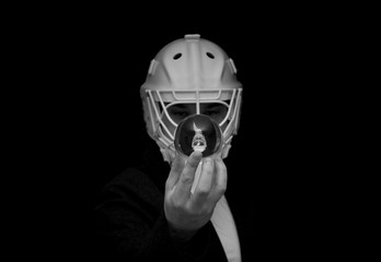 A young man has a goalie helmet on his head and holds a crystal ball with his reflection.Black and white photo.Man in a jacket with a goalie helmet on his head estimates the outcome of the match. - Powered by Adobe