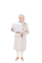 cheerful retired woman reading newspaper isolated on white