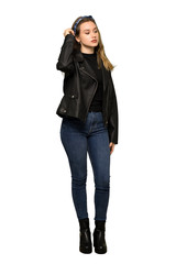A full-length shot of a Teenager girl with leather jacket having doubts while scratching head on isolated white background