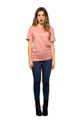 A full-length shot of a Teenager girl with pink sweater with surprise and shocked facial expression on isolated white background
