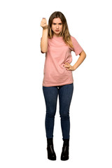 A full-length shot of a Teenager girl with pink sweater making Italian gesture on isolated white background