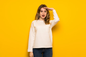 Fototapeta premium Teenager girl over yellow wall has just realized something and has intending the solution