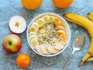 Healthy breakfast. Close-up, top view, isolated background. Concept of healthy and tasty food. Fitness breakfast. muesli bowl with sliced banana. Muesli breakfast with oatmeal cereals raisins. 