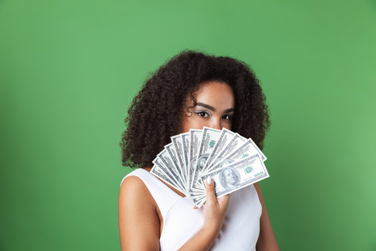 Pretty Young African Woman Posing Isolated Over Green Wall Background Holding Money.